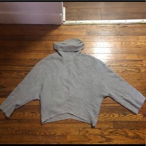 A gray turtle neck sweater